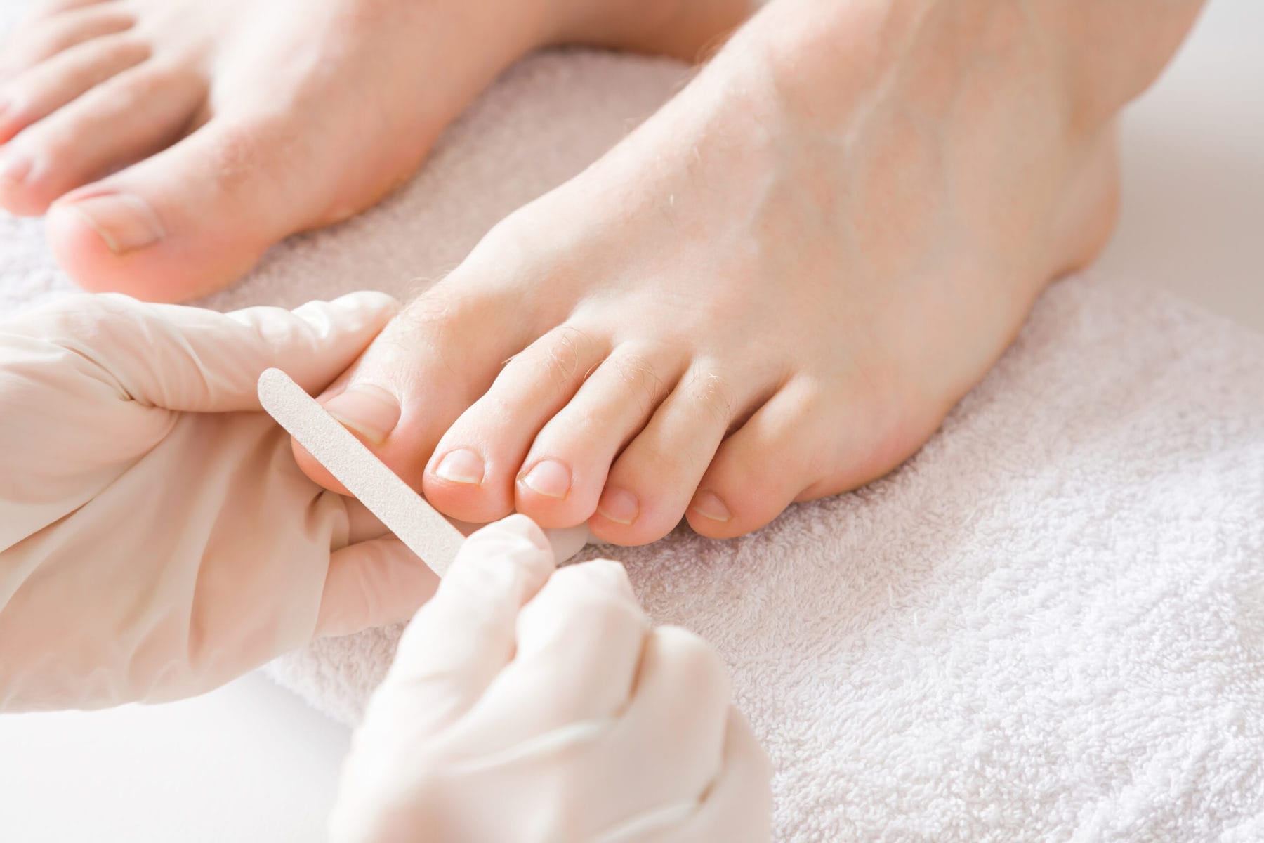 Pedicurist's,Hands,In,Protective,Rubber,Gloves,Filing,Toenails,With,Nail